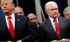 Donald Trump and Jeff Sessions button their coats as they stand for the national anthem at the FBI Academy in Quantico, Virginia in December 2017