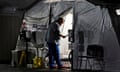 A healthcare worker checks on patients inside an oxygen tent outside the emergency room in Huntington Park, California, on 29 December 2020. 