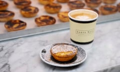 A Portuguese custard tart (pastel de nata) on  a plate with a coffee