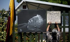 A woman places a banner next to a picture of Gabriel Garcia Marquez.