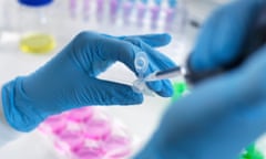 A scientist taking a sample with a pipette.