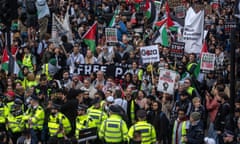 Met police stand in front of a crowd of protesters at a demonstration in London.