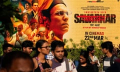 People walk past a large poster of the movie Swatantra Veer Savarkar displayed outside a cinema hall in Mumbai. The movie, set to be released on Friday, is one of several upcoming Bollywood releases based on polarizing issues, which either promote Indian Prime Minister Narendra Modi and his government’s political agenda, or lambast his critics