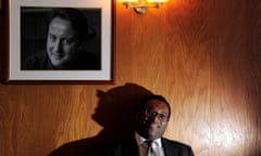 Kwasi Kwarteng posing beneath a picture of Cameron at his constituency office in 2010
