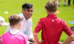 Rishi Sunak kneeling and talking to children at football practice