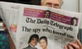 View of the Telegraph front page as it is held up by a man reading the paper on a train