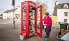 Pusan Crawford, a founder of the phone box community food larder in Muthill, Perthshire, checks the provisions
