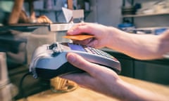 Close up of a hand using a contactless credit card terminal to pay