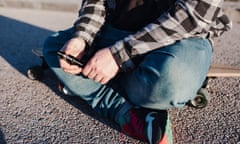 Man sitting cross-legged holding a vape