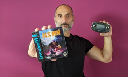Last man standing … Fabio Belsanti, game developer holding a copy of the game and a Game Boy Advance.