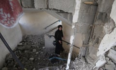 A young woman dressed in black walks through a ruined building.