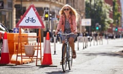 Helen Pidd cycling in a clearly marked cycle lane, Manchester city centre.