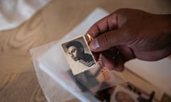 Hand holding a black and white photo of a young John Souisa