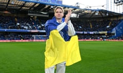 Mykhaylo Mudryk draped in a Ukraine flag as he applauds Chelsea fans at Stamford Bridge on Sunday.