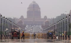 A construction worker walks across a mirage created on a road during a heatwave in Delhi, India.