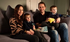 Pete and Rhiannon Hale with their five-year-old twin sons: the family are sitting on a grey sofa and holding a picture-book and yellow toy