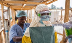 In this photo taken on Monday, March 2,  2015, a health care worker prepares a colleague's virus protective gear before entering a high risk zone at an Ebola virus clinic operated by the International Medical Corps in Makeni, Sierra Leone.  According to the head of the national Ebola response Centre, complacent behavior in Sierra Leone has led to a worrying spike in confirmed Ebola cases over the past week in four districts, Alfred Palo Conteh said Thursday, March 12, 2015.  (AP Photo/ Michael Duff)