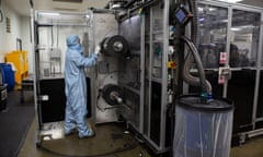 A worker in a protective suit operates machinery