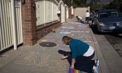 Karen Fagan, joined by her daughters, Kate and Elizabeth Bowman, writes chalk messages on the sidewalk outside the Islamic Center of Claremont in Pomona, California to show their support for Muslim communities on 25 November 2016.