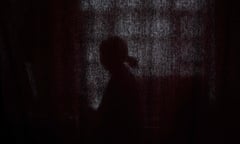 A woman stands behind a curtain to separate female employees from men who work at Radio Begum in Kabul.