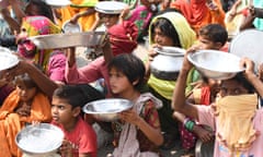INDIA-HEALTH-VIRUS<br>Migrant labourers and their family members from Maharastra hold kitchen utensils as they protest against the government for the lack of food in a slum area, after the government eased a nationwide lockdown imposed as a preventive measure against the COVID-19 coronavirus, on the outskirts of Amritsar on May 31, 2020. (Photo by NARINDER NANU / AFP) (Photo by NARINDER NANU/AFP via Getty Images)