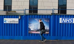 A pedestrian walks past hoarding showing the branding of British construction company Carillion at the collapsed company's construction site