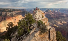 Tourists gather at a viewpoint overlooking a grand canyon landscape.<br>Tourists gathering on a rock outcrop at Bright Angel Point, North Rim, Grand Canyon, Arizona.