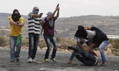 Infiltrated members of the Israeli security forces detain a Palestinian stone thrower and aim their weapons at fellow protesters during clashes in Beit El, on the outskirts of the West Bank city of Ramallah.