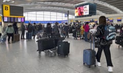 Passengers queue to check in at Heathrow airport