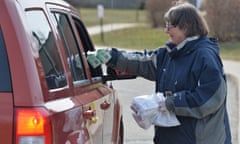 Laurell Beck delivers bagged lunches and breakfasts to a school family member, March 16, 2020, at Tracy Elementary School in Millcreek Township, Erie County, Pennsylvania. Beck is part of the school's cafeteria staff. On Monday, the Millcreek Township School District began providing meals to their school families at five schools in the district, as part of their coronavirus planning. Pennsylvania Gov. Tom Wolf, on March 13, 2020, closed all schools in the state for two weeks. (Christopher Millette/Erie Times-News via AP)