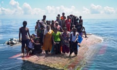 Rohingya rescued at sea after boat capsized<br>epaselect epa11233062 Rohingya survivors stand on a capsized wooden boat as they wait for rescuers to evacuate them on to a National Search and Rescue boat in the waters off West Aceh, Indonesia, 21 March 2024. Indonesian rescuers had rescued at least 69 Rohingya, who had been discovered by fishermen on 20 March, standing on the hull of their capsized wooden boat in waters near the city of Meulaboh in West Aceh, according to Indonesian national rescue agency Basarnas. EPA/ZAINAL ABIDIN