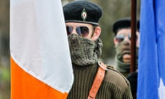 Man in a paramilitary uniform, including beret, sunglasses, face scrim and army military jumper takes part in an Easter Rising commemorative march by the Irish Republican Socialist Party.<br>GWN7XK Man in a paramilitary uniform, including beret, sunglasses, face scrim and army military jumper takes part in an Easter Rising commemorative march by the Irish Republican Socialist Party.
