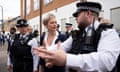 Yvette Cooper out on an urban street with a police woman on one side of her and a police man on the other