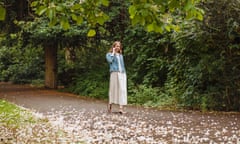 Young woman chatting on smartphone while strolling in park