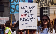 A person holding up a sign saying: 'Cut the wait, not the weight!'