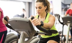 A woman training on an exercise bike in a gym