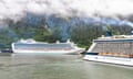 Two huge cruise ships in a large sound with tree-clad mountains in the background