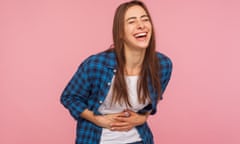 Portrait of extremely happy girl in checkered shirt holding her stomach and laughing out loud, chuckling giggling at amusing anecdote, sincere emotion. indoor studio shot isolated on pink background