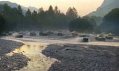A scene from the Toyota Hilux ‘born to roam’ campaign showing vehicles driving through a river against a backdrop of forested terrain