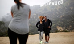 Hikers pose for a photo in front of the Hollywood sign.