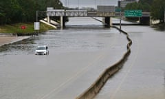 A stranded car on Interstate 10 surrounded by floodwater