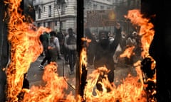 Protester holds placard amid burning shop window