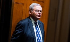 Short sort of fat man with round head in blue suit in wood-paneled elevator.