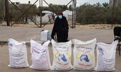 A Palestinian woman stands next to flour bags distributed by UNRWA (United Nations Relief and Works Agency for Palestine Refugees in the Near East) in Rafah, southern Gaza Strip, 28 January 2024.