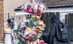 A pupil views floral tributes at the scene
