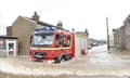 A fire engine drives through flood water in Kendal after Storm Desmond wreaked havoc in the county of Cumbria