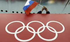 A Russian flag is held above the Olympic rings