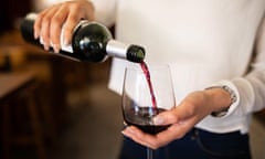 A woman pours a glass of red wine