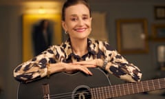 Linda Thompson seated with an acoustic guitar