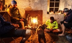 Mountain bikers warm by the fire at Lairig Leacach Bothy